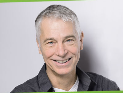 Osteopathie Berlin Portrait von dem Osteopath Normen Wolke auf dem Logo der Osteopathie Praxis Berlin mit drei energetischen Linien